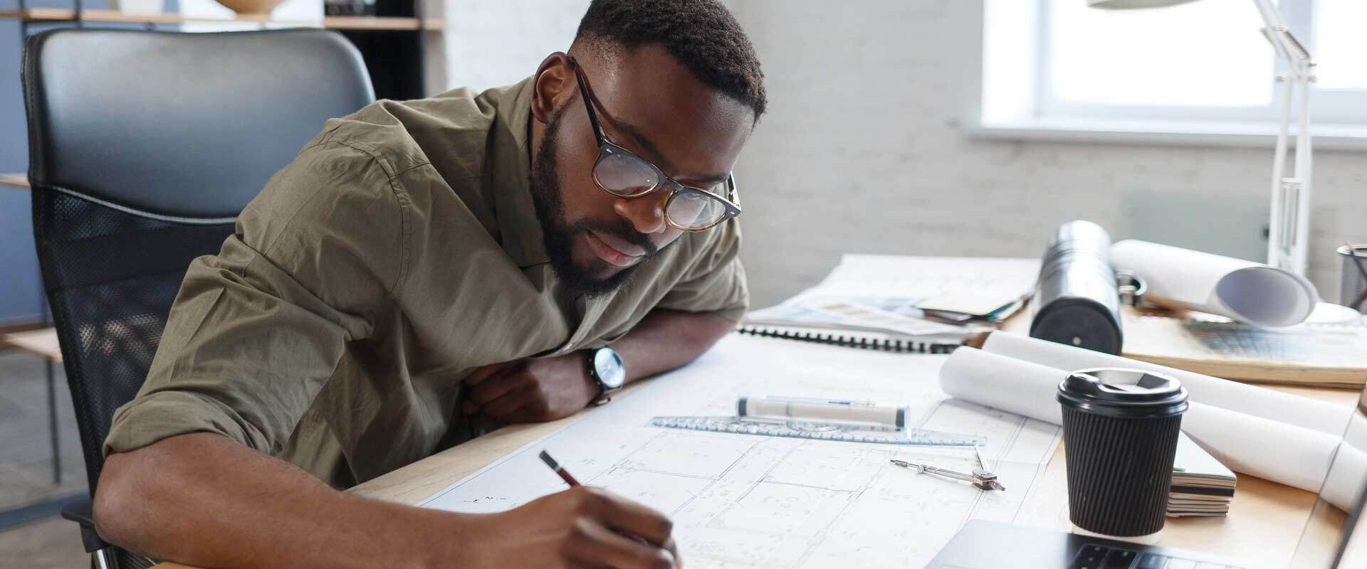 POC male working on an architectural drawing